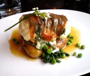 Lækker gourmetmad med kød, sovs og grøntsager.