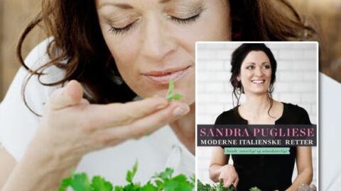 Kvinde med friske urter og italiensk kogebog