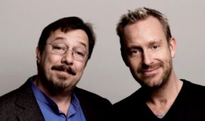 To smilende mænd foran neutral baggrund