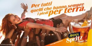 Aperol Spritz-drink reklame med smilende kvinde og hænder.