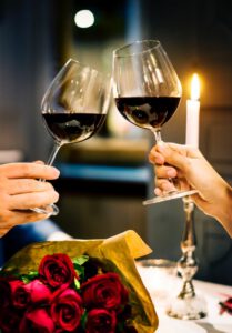 Toasting med rødvin på en romantisk middag