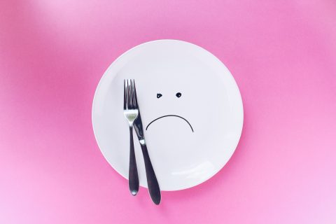 Tallerken med trist ansigt og bestik