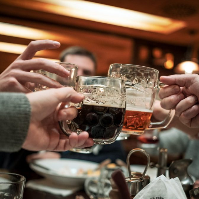 Folk skåler med ølglas på en restaurant