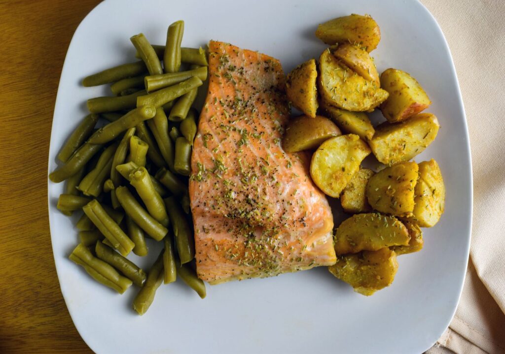 Aeldre par laver sund mad med fisk og grønt i køkken