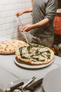 Pizzadej rulles ud på bord