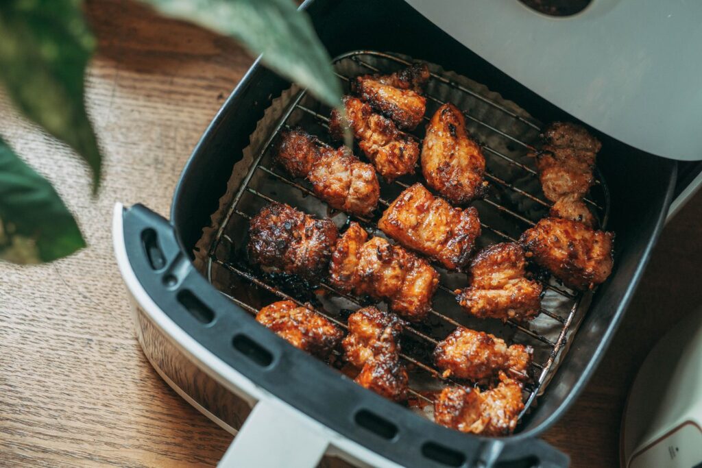 Airfryer på køkkenbord med sprød mad