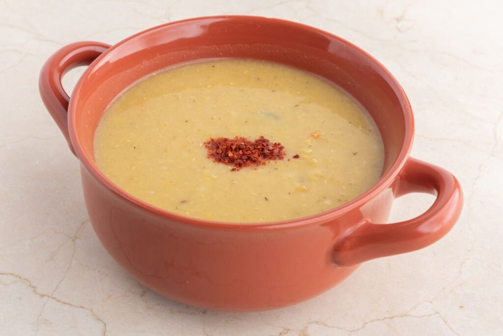 Varm linsesuppe i skål med brød