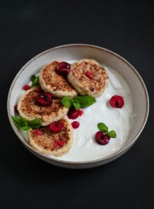 Nybagte boller på rist med skyr i skål ved siden