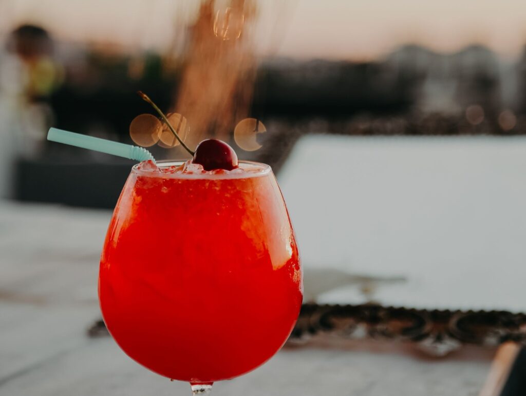 Rød Shirley Temple-drik i glas med kirsebær og sugerør