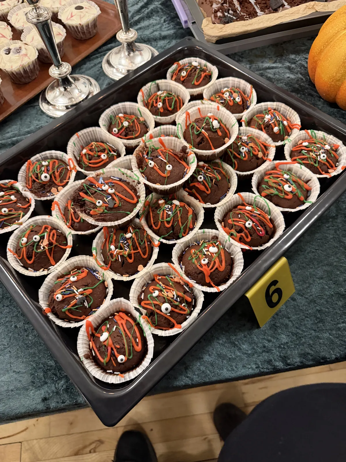 Mørke muffins med orange og grøn pynt og små hvide øjne.